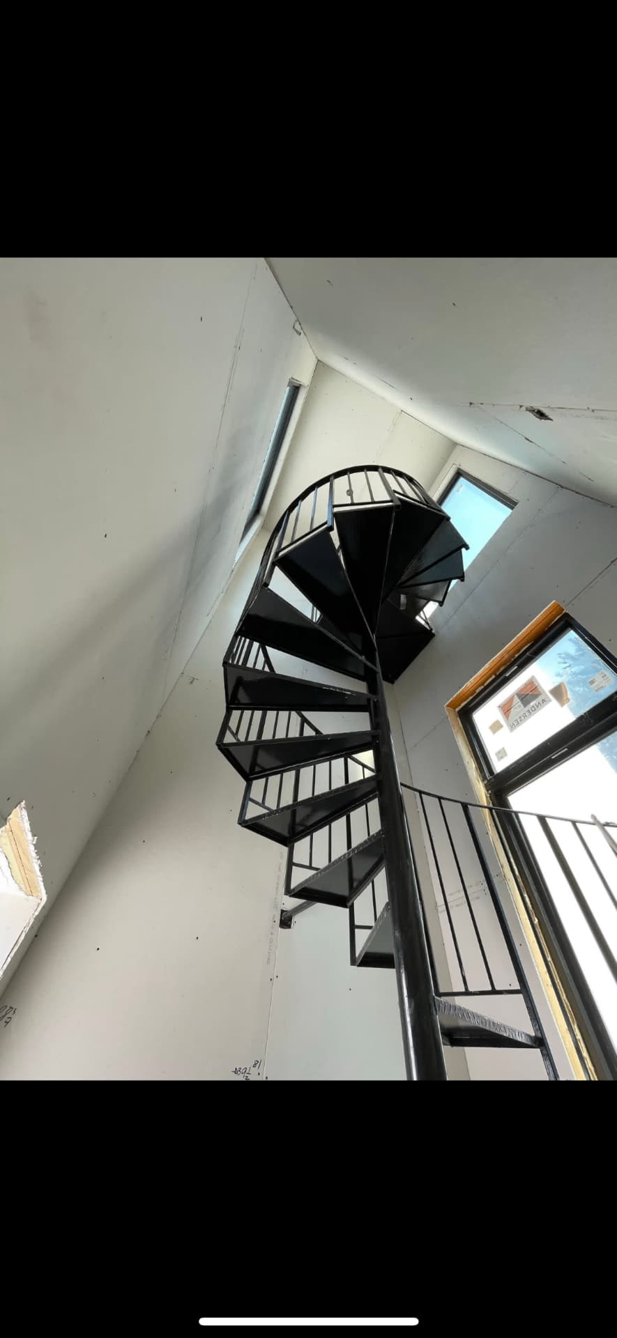 Stairwell drywall finished around a spiral staircase