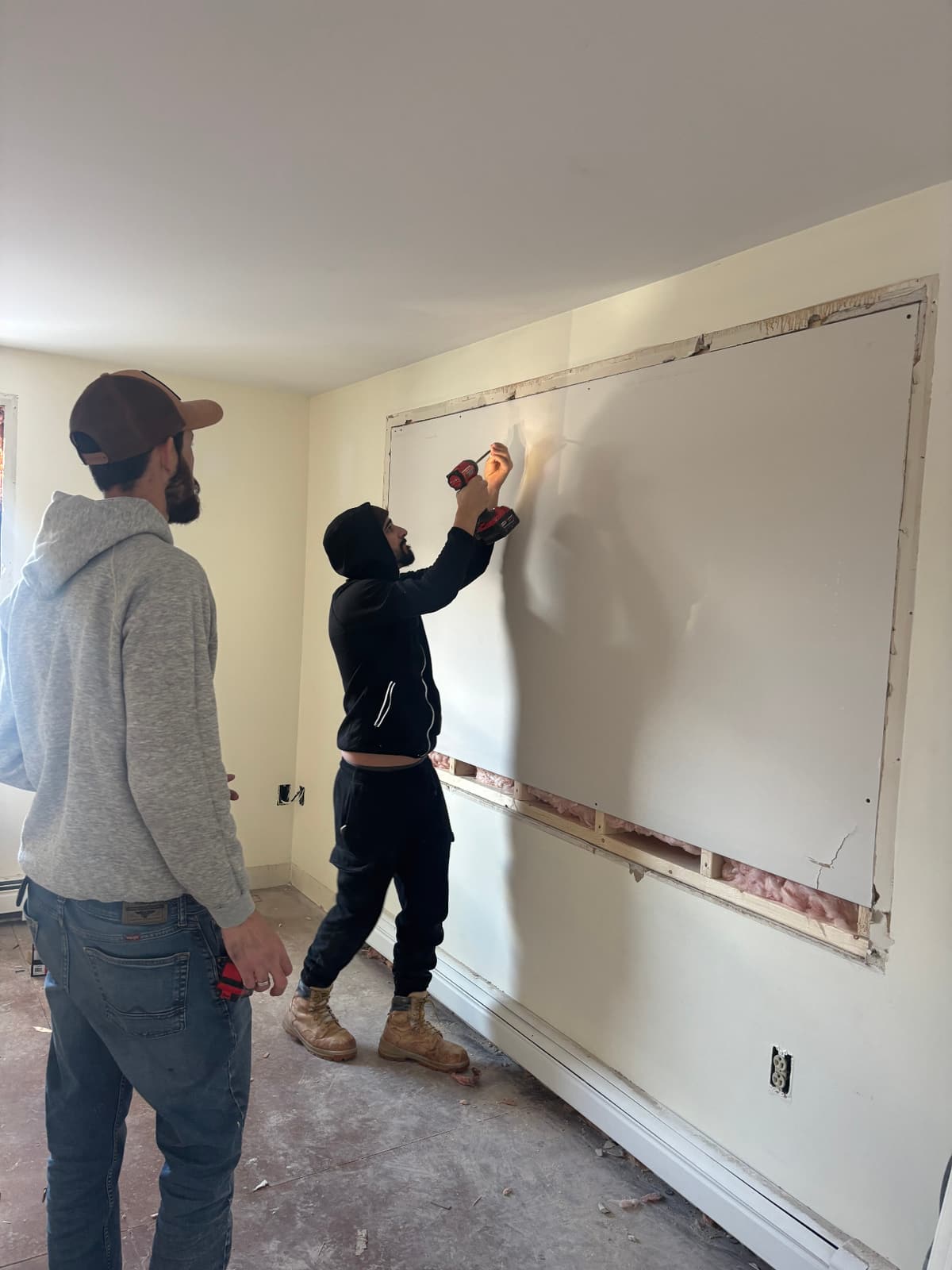 Two-person crew patching a large wall opening