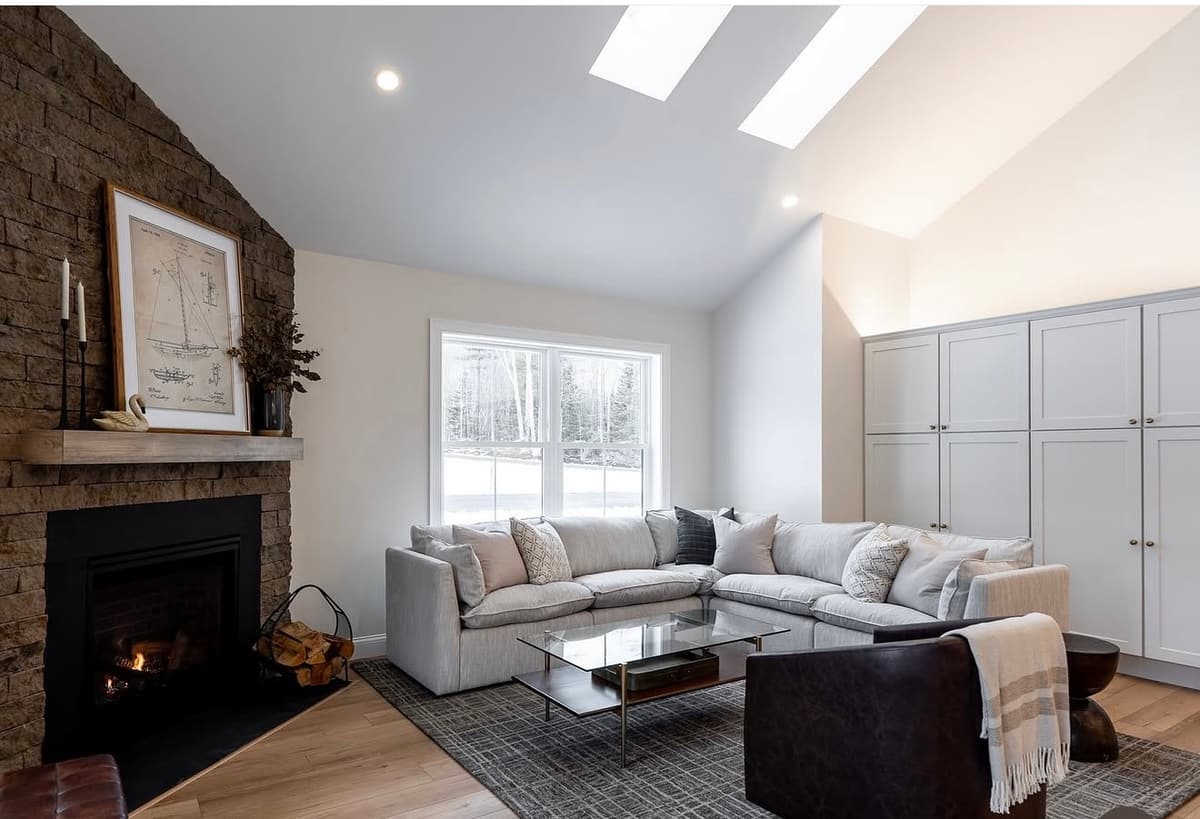 Vaulted living room with stone fireplace repainted by J&B Drywall & Paint